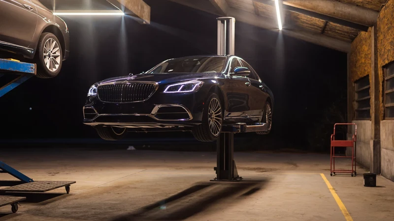 Illustrierte Werkstatthalle bei Nacht mit Limousine auf der Hebebühne