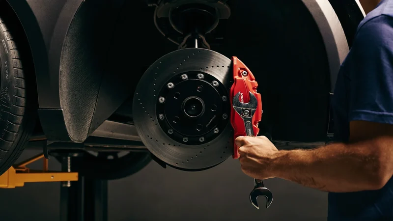 Illustration: Bremsscheibe und roter Sattel mit Drehmomentschlüssel